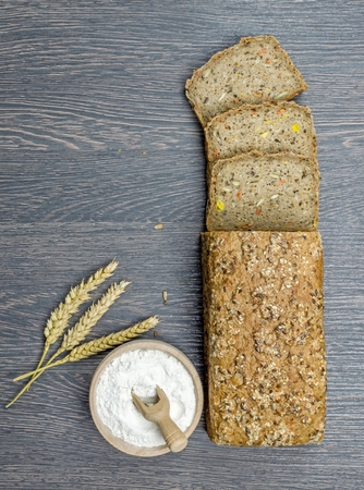 A sliced wholemeal grain loaf on wooden background with copy spaceの写真素材