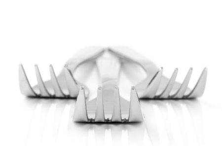 An abstract close up image of a group of forks on a white surface
