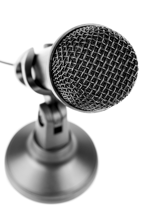 A close up of a black microphone on a stand against a white backgroundの写真素材