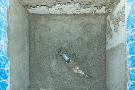 A top down view of new concrete flooring with drain pipe during a bathroom shower unit renovation modernization projectの写真素材