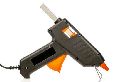 An electric hot glue gun pistol tool loaded with an adhesive stick on a white backgroundの写真素材
