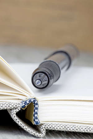 A close up of a pen lying on an open journal diary notebook with copy space for your textの写真素材
