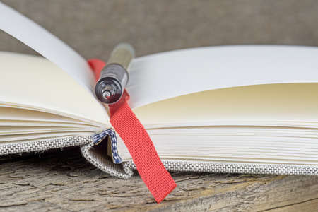 An open journal diary notebook with pen on a wooden tableの写真素材