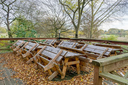 An outdoor seating area of a cafe restaurant with tables and benches chained up due to coronavirus lockdown regulationsの写真素材