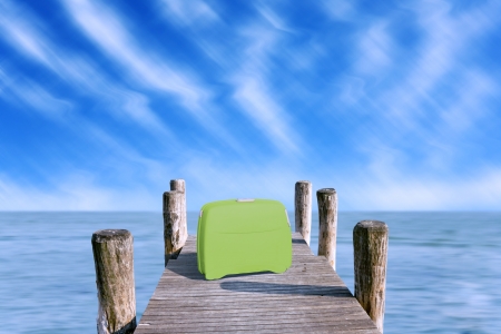 green suitcase parked on the pierの写真素材