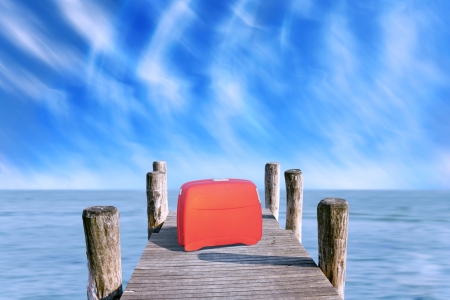 red suitcase parked on the pierの写真素材