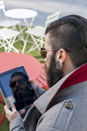 young hipster consults his tabletの写真素材