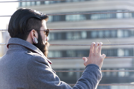 young businessman hipster look at traffic through an iron bridgeの写真素材