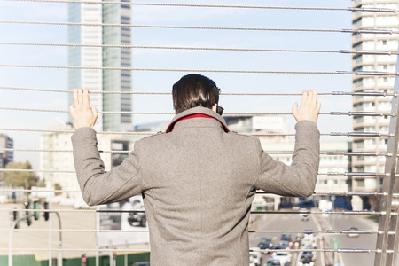 young hipster look at traffic on an iron bridgeの写真素材