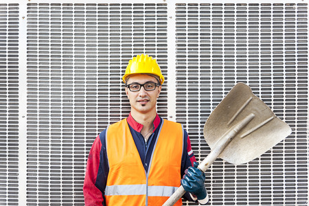 portrait of a young engineer wearing a helmet against metal backgroundの写真素材
