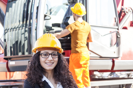 young female engineer posing in junkyard with a worker