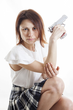 sexy woman posing with gun on white backgroundの写真素材