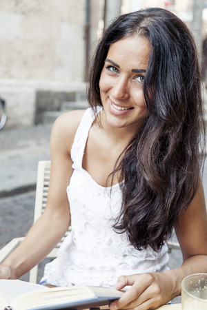 portrait of attractive girl while reading book in a coffee barの写真素材