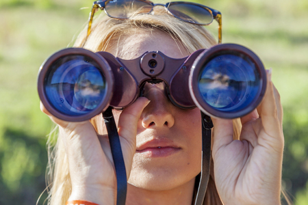 pretty girl with binoculars looking at the horizonの写真素材