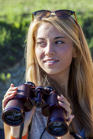 pretty girl with binoculars looking at the horizonの写真素材