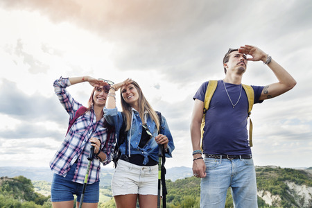 group of young adults looks to the horizon during hikingの写真素材