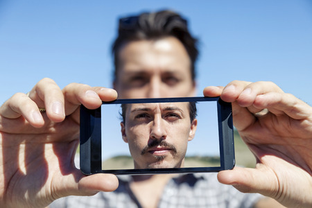 young cute adult take a selfie with smart phoneの写真素材