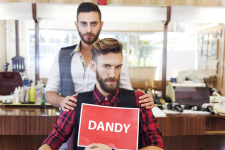 young hipster couple posing in their vintage barber shopの写真素材