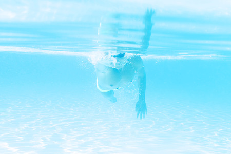young man swimming the front crawl style in a poolの写真素材