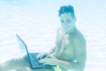 young man enjoying his laptop underwaterの写真素材