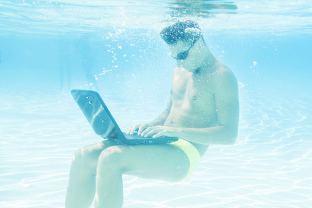 young man working with his laptop underwaterの写真素材