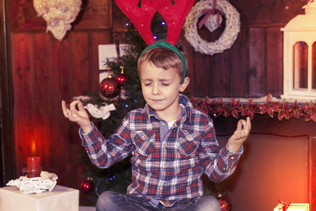 young boy waiting for santa claus sitting on the tableの写真素材