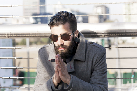 young hipster relaxes on an iron bridgeの写真素材