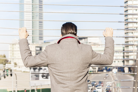young hipster look at traffic on an iron bridgeの写真素材