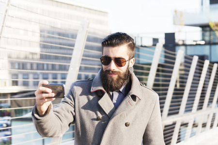young hipsters businessman take selfie in a modern cityの写真素材