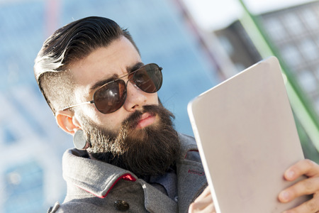 young hipster businessman consults his laptop in the heart of cityの写真素材