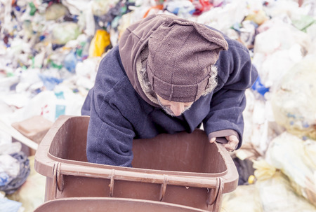 homeless rummages in the dustbin of landfill