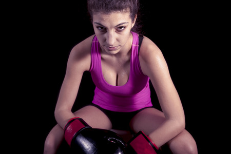 young attractive girl with boxing gloves on black background
