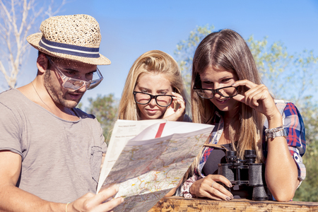 group of young hikers search on the map the right wayの写真素材