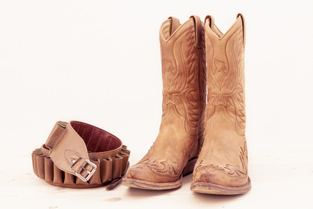 vintage boots with cartridge belt isolated on white backgroundの写真素材