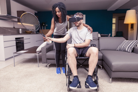 young girl helps a disabled who plays tennis with augmented realityの写真素材