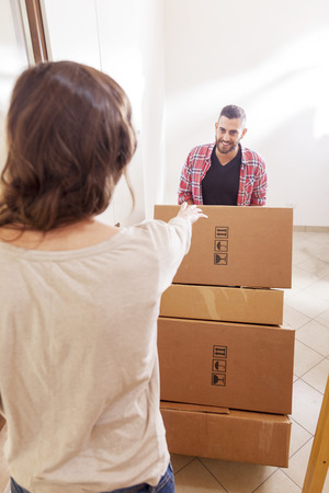 young couple carrying the boxes in new houseの写真素材