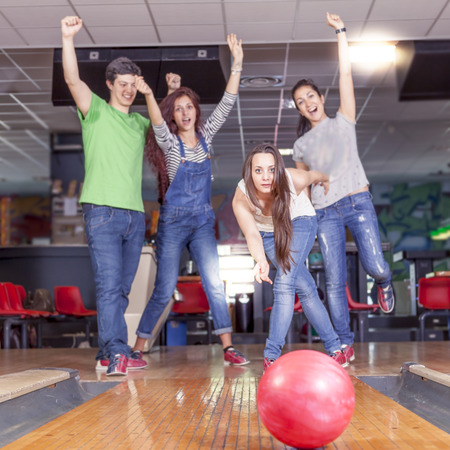 group of young adults having fun playing on the bowling alleyの写真素材