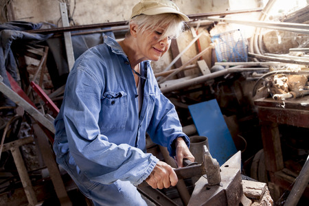 beautiful lady at work in his old workshopの写真素材