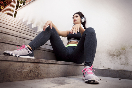 young female runner relaxing listening to music from headphonesの写真素材