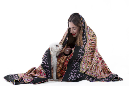 pretty girl plays with her dog under a blanket on white backgroundの写真素材