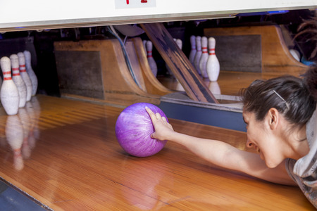 young woman sliding down a bowling alleyの写真素材