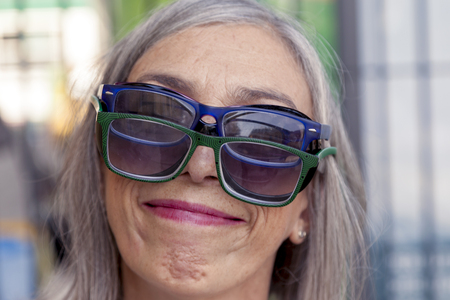 funny portrait of lady with lots of glasses on his headの写真素材