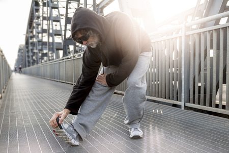 athlete doing stretching on metal bridge. Healthy lifestyle and sport conceptの写真素材