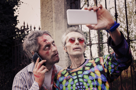 scary bloody zombies men takes a selfie in a cemeteryの写真素材