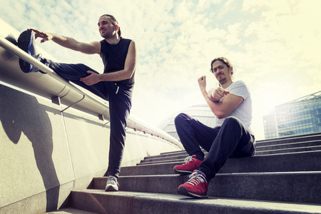 athletic young adults are stretching in front of the city hall of Londonの写真素材