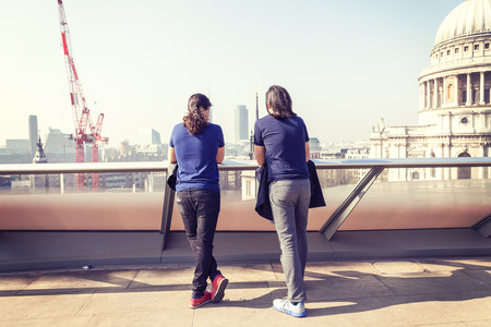 happy young adults on a London terrace watching the viewの写真素材