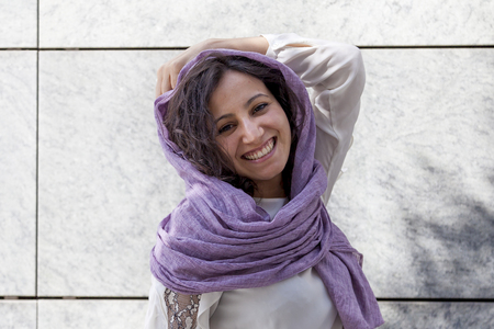 Portrait of young woman in front of a marble wallの写真素材