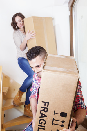 young couple carrying the boxes in new houseの写真素材