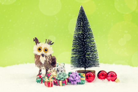 miniature of christmas tree with colored gifts boxes in the snow on green background. christmas holiday celebration conceptの写真素材
