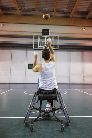 disabled sport men in action while playing indoor basketball at a basketball courtの写真素材